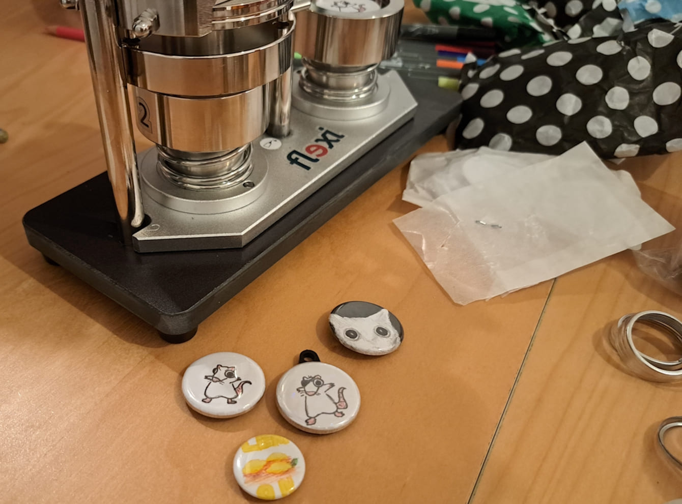 Vier lustige Buttons neben einer Buttonmaschine.