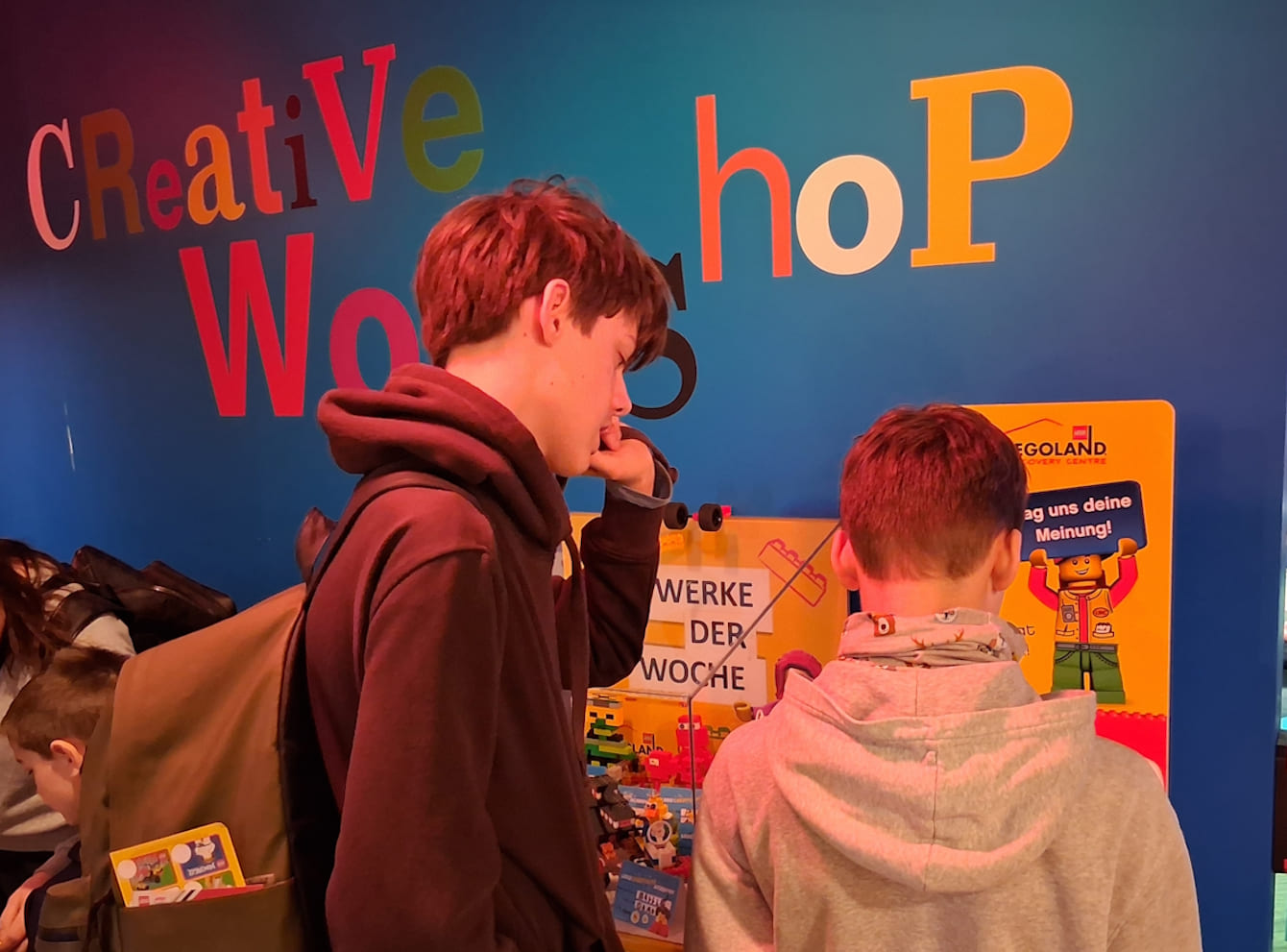 Zwei Kinder stehen vor einer bunten Wand im Legoland.