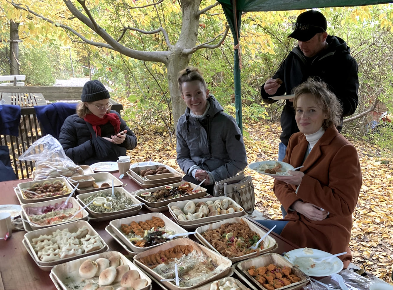 Drei Frauen und ein Mann essen unter einem Baldachin. Vor ihnen ein Buffet mit orientalischen Spezialitäten.