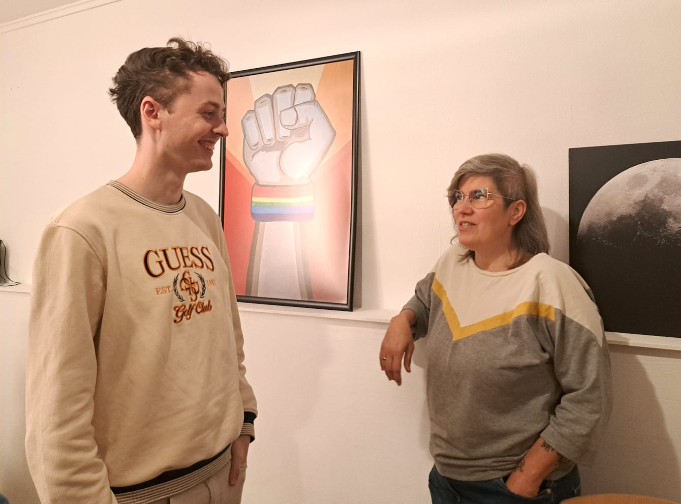 Lars von MANEO und Projektleiterin Connie von Q unterhalten sich vor einer Wand.