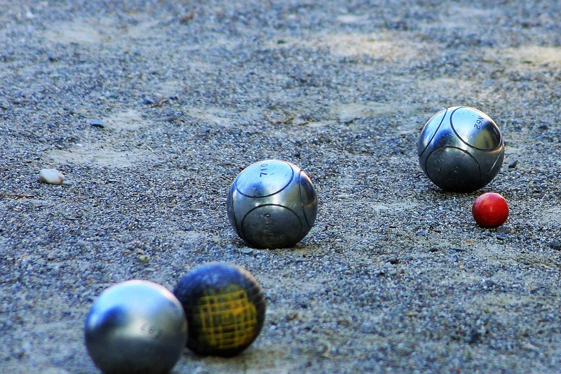 Silberne Boule-Kugeln mit einer roten auf Sand